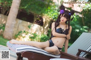 A woman in a bikini posing by a pool.