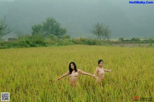 A naked woman sitting on a wooden bench.