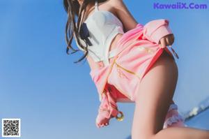 A woman in a white bikini sitting on a playground.