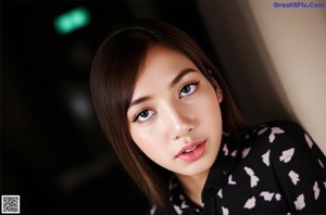 A woman in a green shirt is posing for a picture.