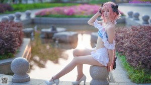A woman in a pink and white outfit pointing at the camera.