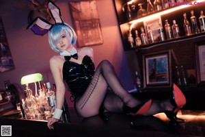 A naked woman sitting at a bar with a bunny ears headband.