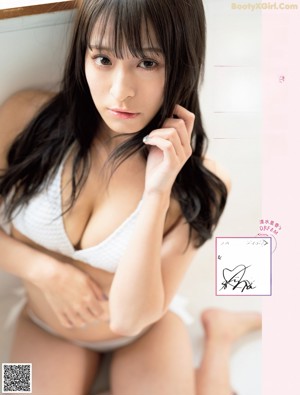 A woman in a white bikini posing for a magazine.