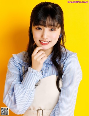 A woman with long black hair and a blue and white striped shirt.