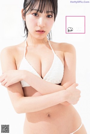 A woman in a white bikini posing for a magazine.