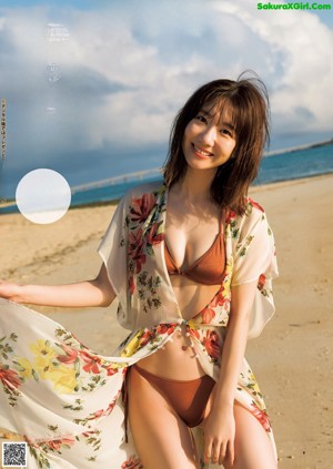 A woman in a pink and white striped bikini posing for a picture.