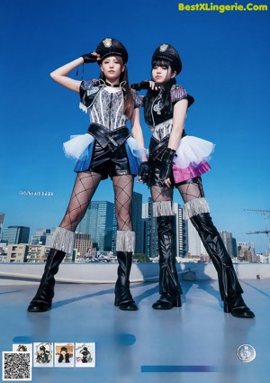 A woman sitting on top of a wooden bench next to another woman.