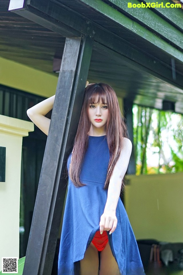 A woman in a blue dress posing for a picture.