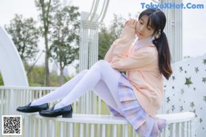 a woman in a white shirt and purple plaid pants