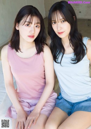 A couple of women standing next to each other in the grass.