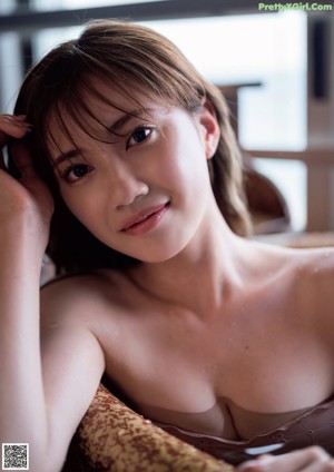 A woman in a pink lingerie sitting on a chair.