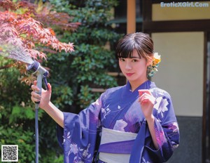 A woman in a purple kimono sitting on a table.