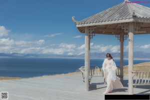 A woman sitting on a wooden bench holding a mirror.