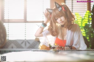 A woman in a cat costume sitting on a couch.