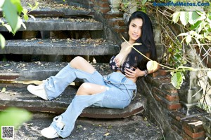A woman in a denim skirt posing for the camera.