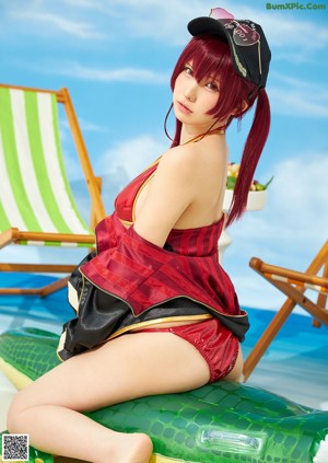 A woman with red hair sitting on an inflatable pool float.