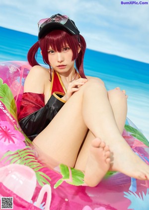 A woman in a bikini sitting on an inflatable pool float.