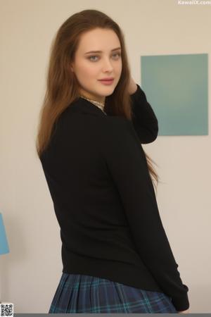 A woman in a black dress posing on a bed.